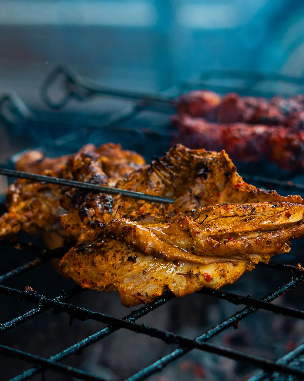 Spiced grilled chicken pieces cooking on the grill